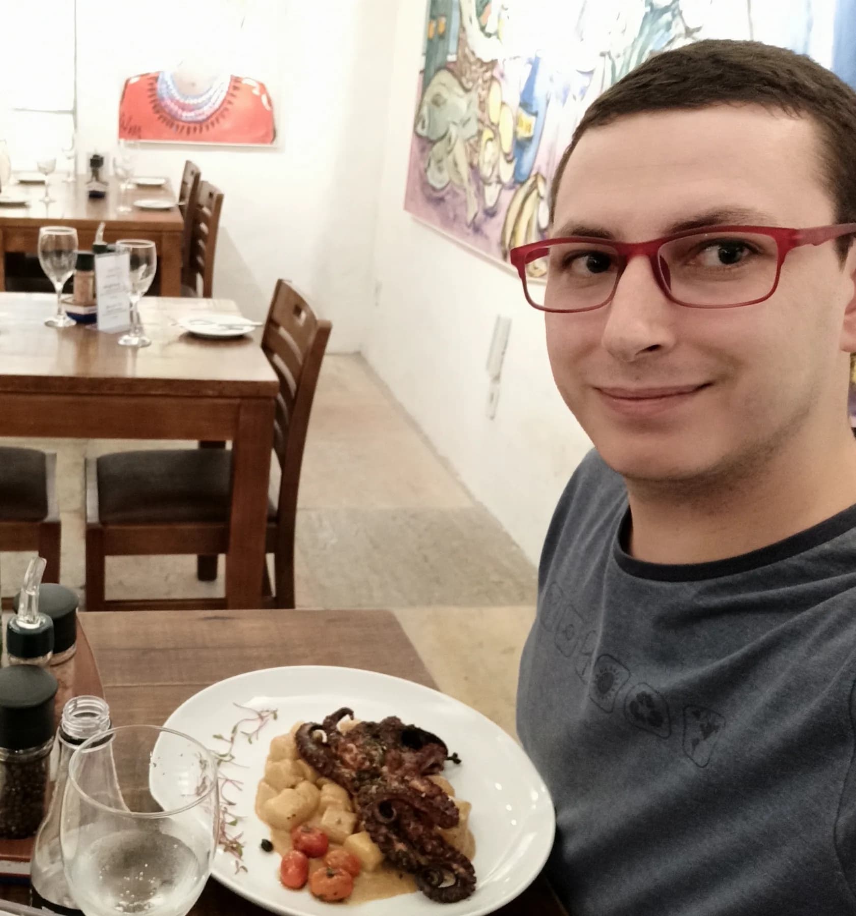 Chef Anderson, do Bistrô Chef Lau, à mesa com um prato de polvo grelhado e nhoque
