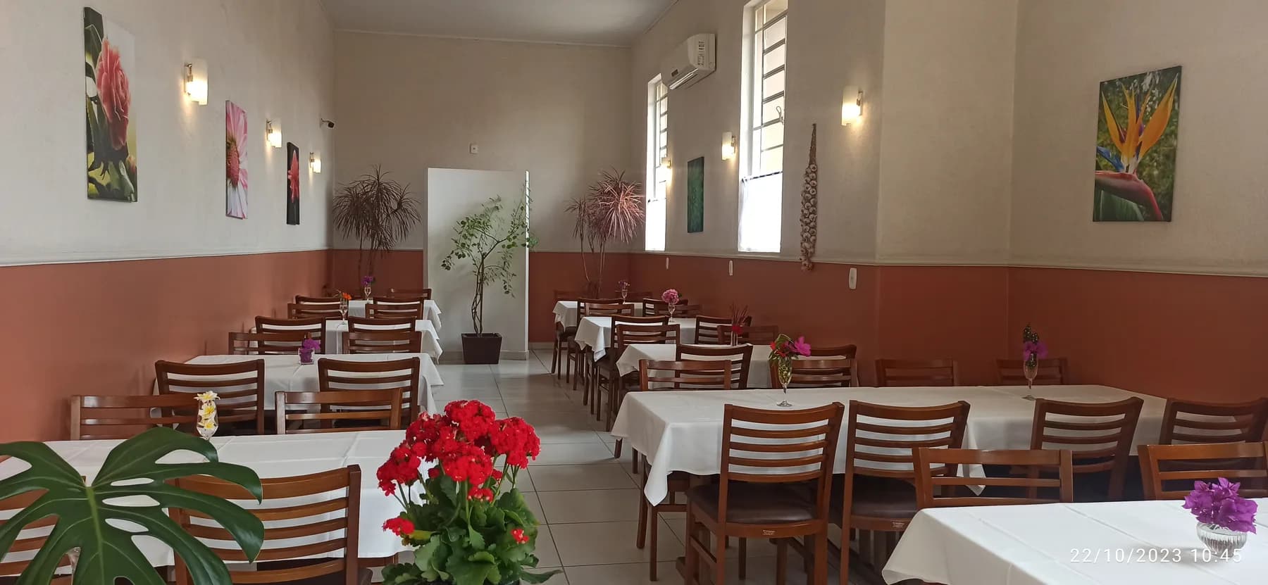 Salão acolhedor do Bistrô Chef Lau em Muzambinho/MG, mesas com toalha branca e parede em terracota — foto real